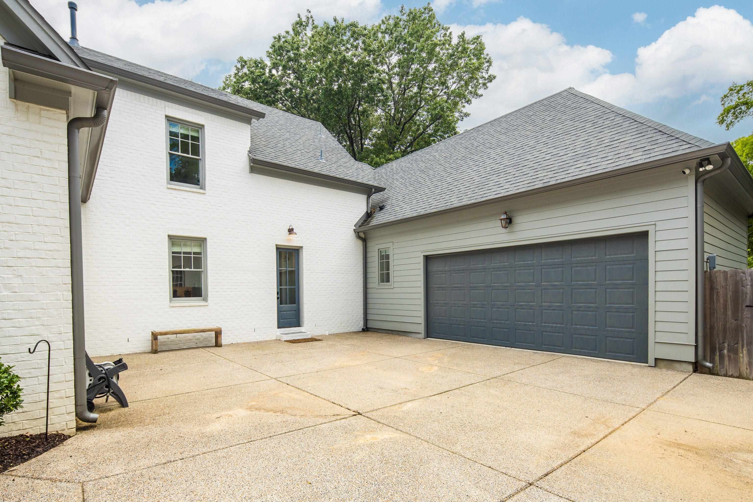 1133 Hayne Road Memphis, TN 38119 - Photo 31 of 34 View of home's exterior featuring concrete driveway, a garage, a shingled roof, and brick siding