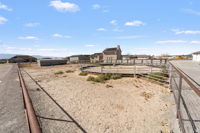 3678 Spiral Springs Road, Unit 204 Tooele, UT 84074 - Photo 53 of 59 Expansive land parcel featuring an equestrian arena with metal fencing and a gravel driveway