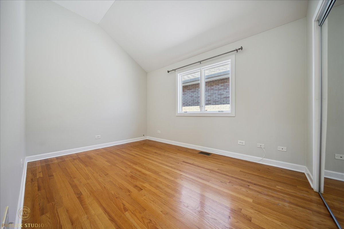 2929 North Rutherford Avenue Chicago, IL 60634 - Photo 21 of 26 a view of an empty room with wooden floor and a window
