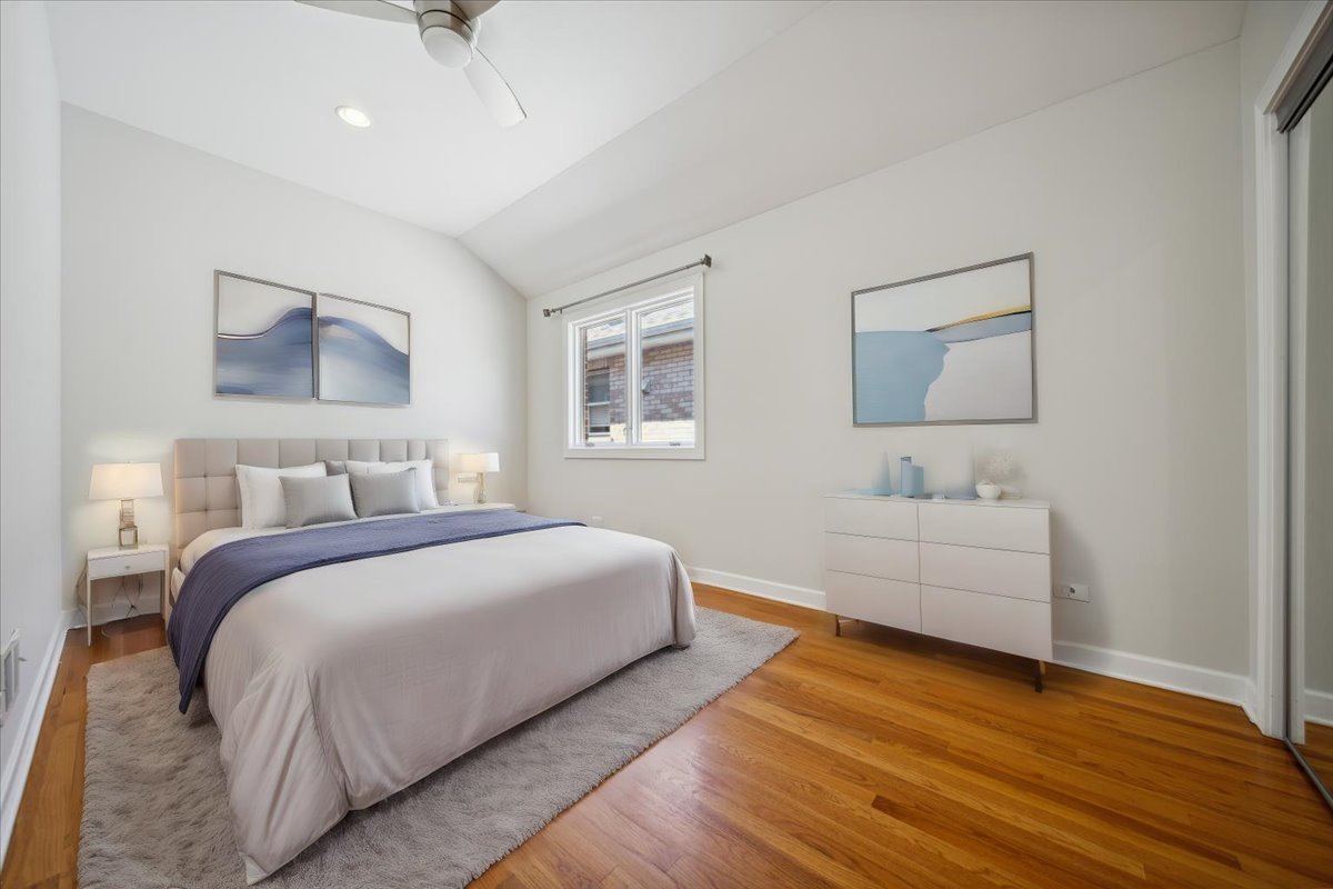2929 North Rutherford Avenue Chicago, IL 60634 - Photo 4 of 26 a bedroom with a white bed and a couch