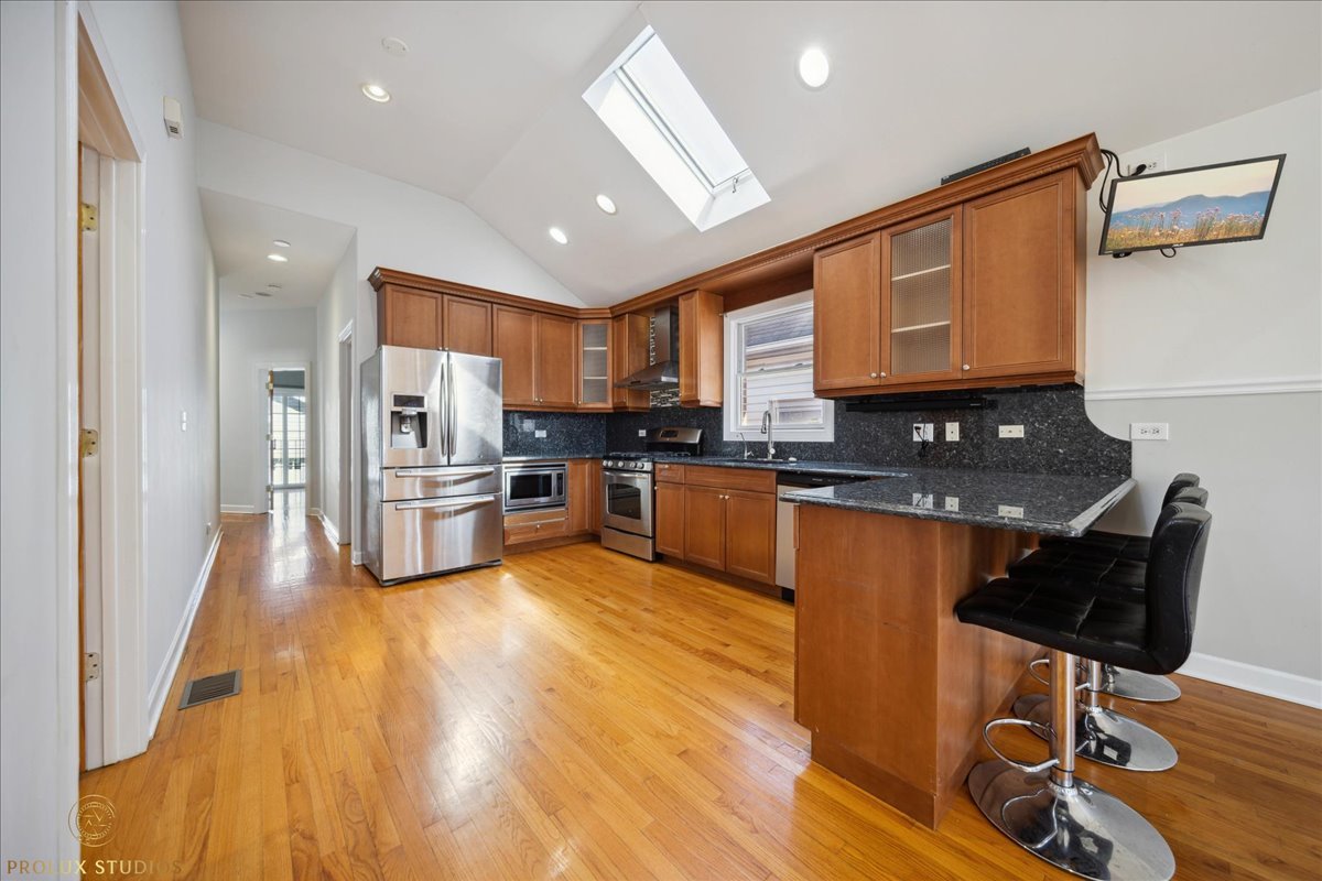 2929 North Rutherford Avenue Chicago, IL 60634 - Photo 6 of 26 a large kitchen with stainless steel appliances granite countertop a stove a sink dishwasher and a refrigerator