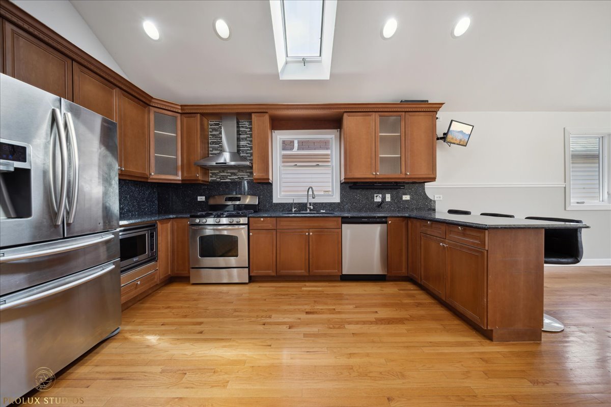 2929 North Rutherford Avenue Chicago, IL 60634 - Photo 8 of 26 a kitchen with stainless steel appliances granite countertop a stove a sink and a refrigerator