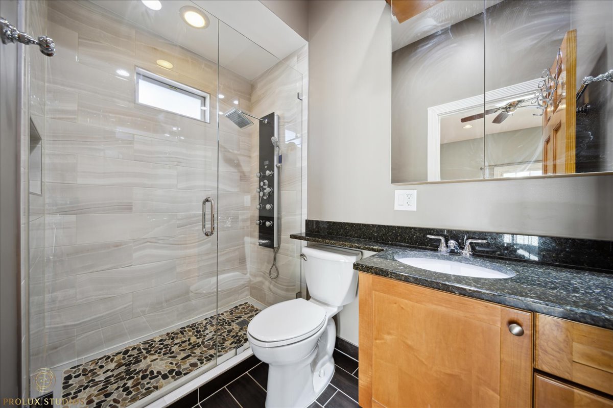 2929 North Rutherford Avenue Chicago, IL 60634 - Photo 9 of 26 a bathroom with a granite countertop sink toilet and shower