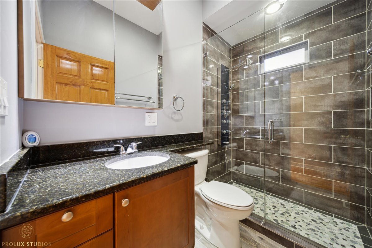 2929 North Rutherford Avenue Chicago, IL 60634 - Photo 10 of 26 a bathroom with a granite countertop toilet sink and mirror