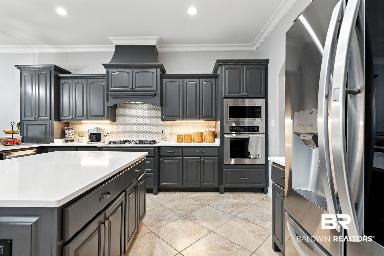 23357 Carnoustie Drive Foley, AL 36535 - Photo 38 of 99 Kitchen featuring stainless steel appliances, crown molding, tasteful backsplash, light countertops, and light tile patterned floors