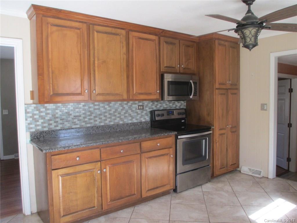 2312 Sunshine Road Lancaster, SC 29720 - Photo 14 of 16 a kitchen with stainless steel appliances granite countertop a stove and a microwave