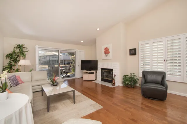 a living room with furniture a fireplace and a floor to ceiling window