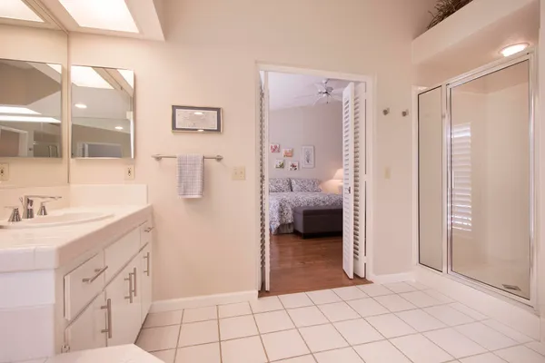 a spacious bathroom with a sink a mirror and a shower