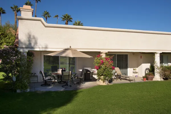 a view of a house with furniture and garden