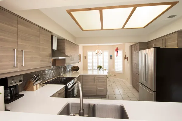 a kitchen with a sink a counter top space and stainless steel appliances