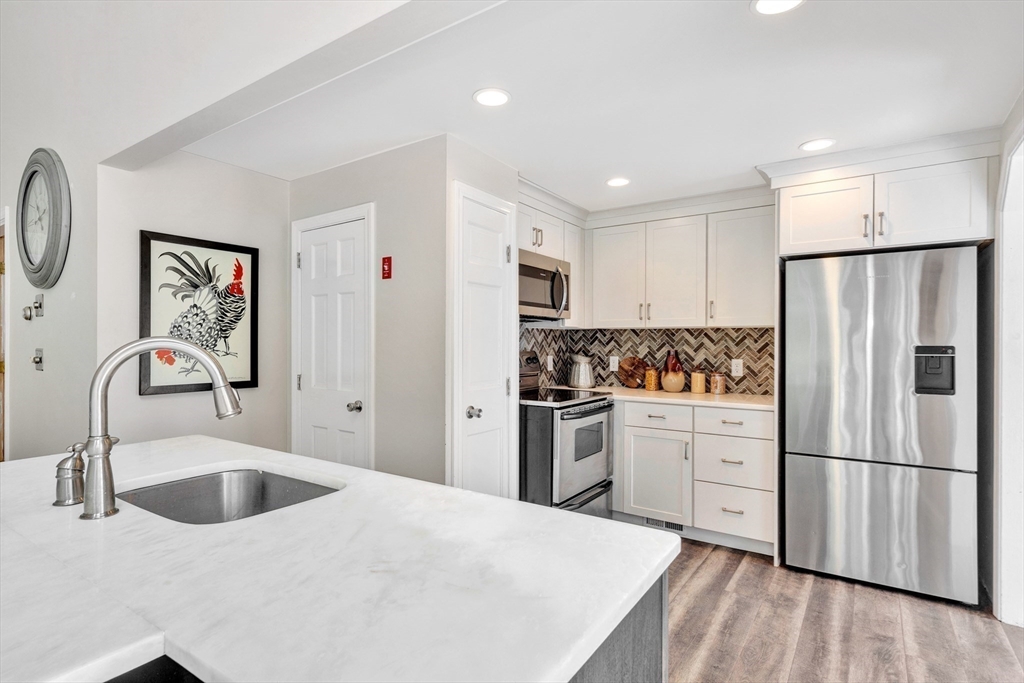118 Woolford Road Wrentham, MA 02093 - Photo 12 of 41 a kitchen with granite countertop a refrigerator sink and white cabinets