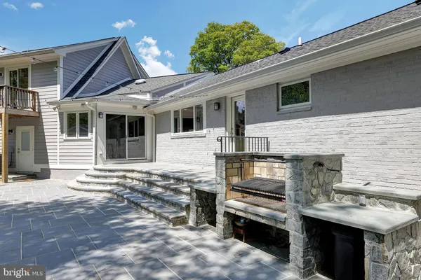 a view of a house with a barbeque grill and a fireplace