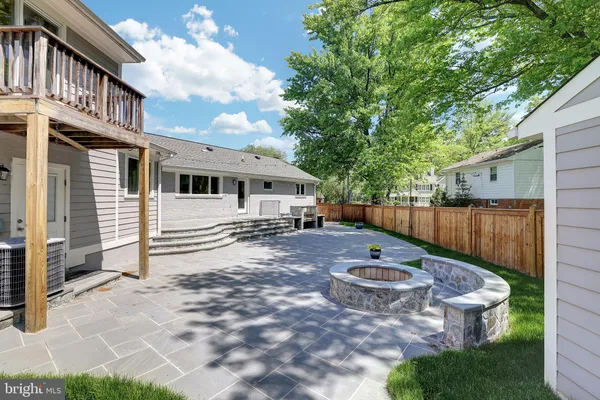 a view of a patio with table and chairs and wooden fence