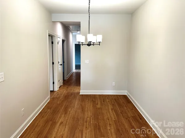 a view of a room with wooden floor and a ceiling fan