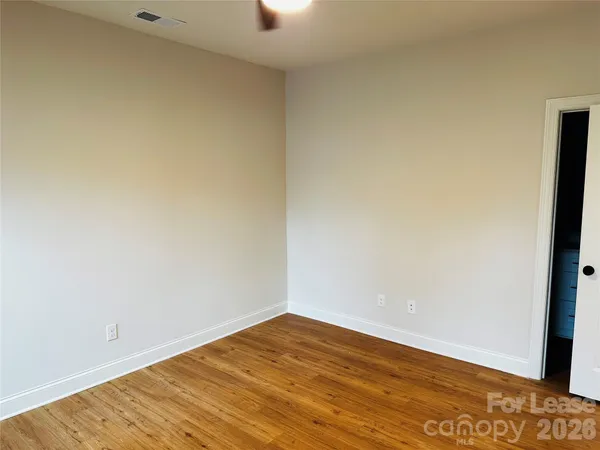 a view of empty room with wooden floor