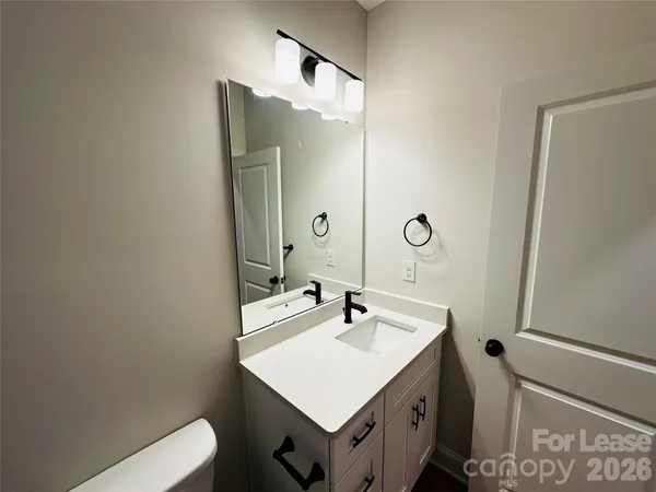 a bathroom with a sink a toilet and a mirror