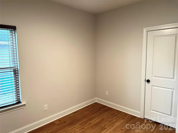 a view of a small space with wooden floor and a window
