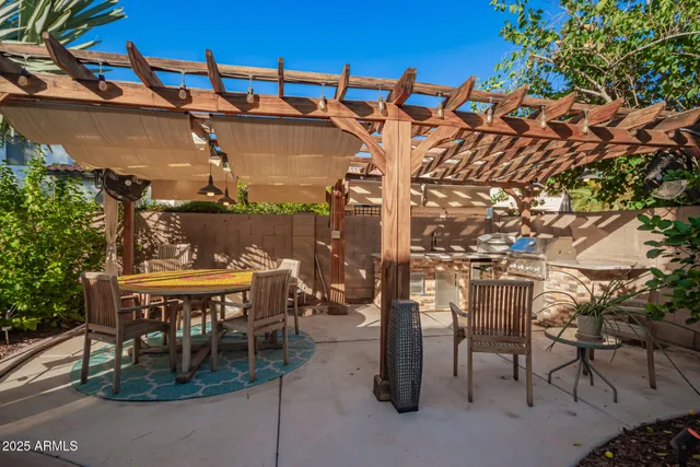 a patio with a table and chairs under an umbrella