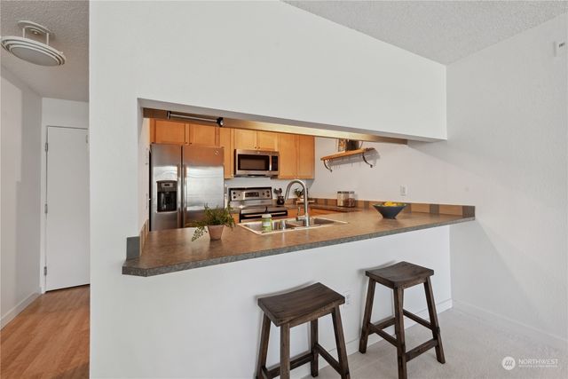 a kitchen with stainless steel appliances granite countertop a sink a stove and white cabinets