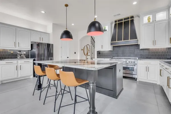a kitchen with stainless steel appliances granite countertop a sink a stove and a refrigerator