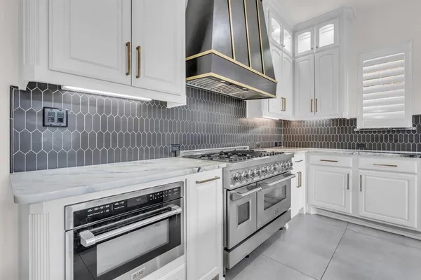 a kitchen with granite countertop a stove sink and cabinets