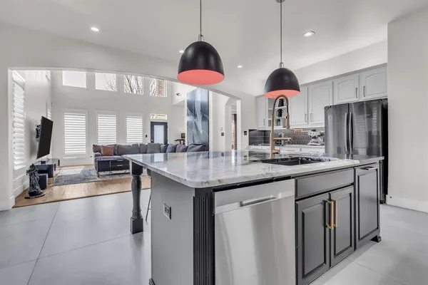 a kitchen with stainless steel appliances granite countertop a sink a stove and refrigerator