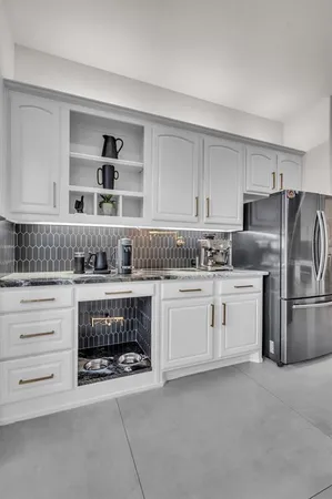 a kitchen with granite countertop white cabinets and stainless steel appliances