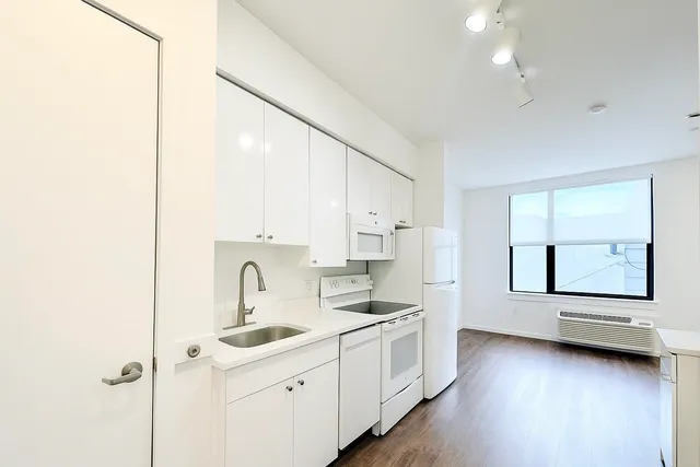 a kitchen with white cabinets and white appliances