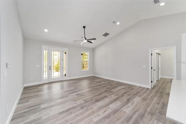 a view of an empty room with window and wooden floor
