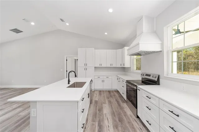 a kitchen with granite countertop a sink stove and refrigerator