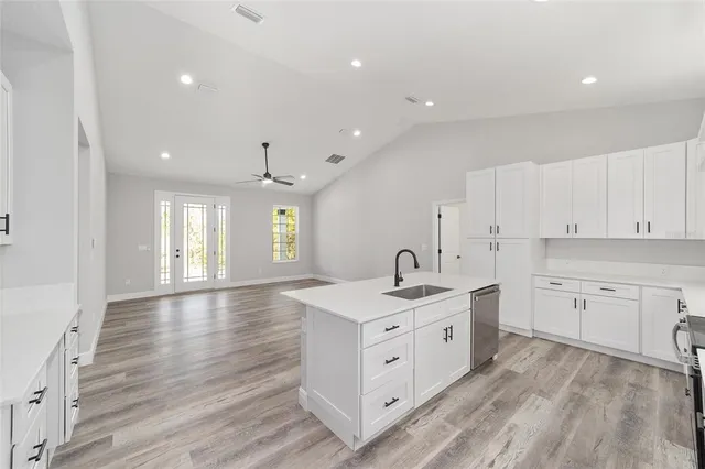 a spacious bathroom with double vanity a window and a bathtub