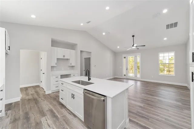 a kitchen with a sink a stove a refrigerator and white cabinets