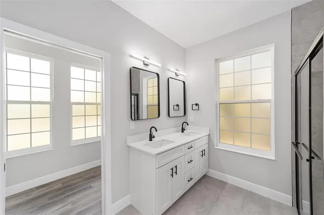 a bathroom with double vanity and a window