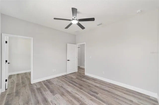 a view of empty room with wooden floor