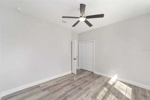 a view of a room with wooden floor and a ceiling fan