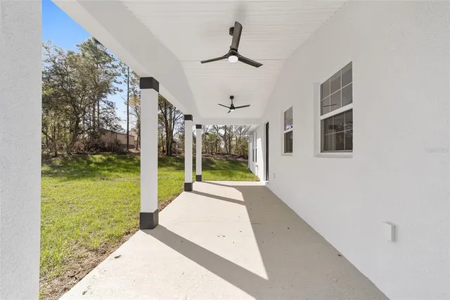 a view of a porch in front of a house with a big yard