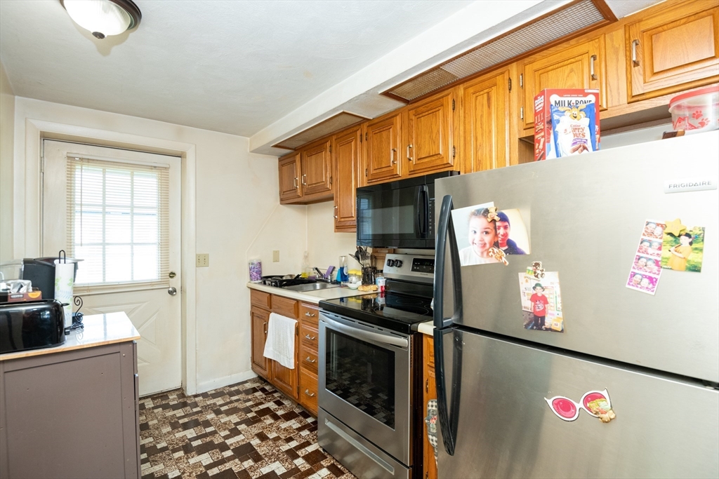 24 Webb Street Salem, MA 01970 - Photo 30 of 38 a kitchen with granite countertop stainless steel appliances a stove a sink and a refrigerator
