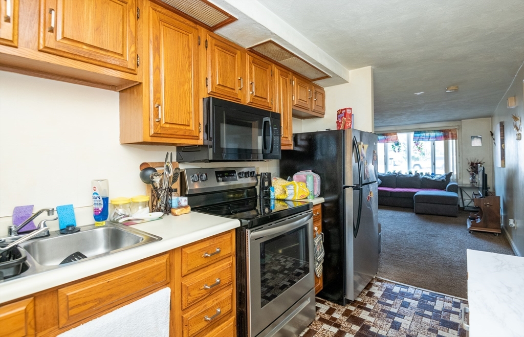 24 Webb Street Salem, MA 01970 - Photo 31 of 38 a kitchen with a sink dishwasher stove and microwave with wooden floor