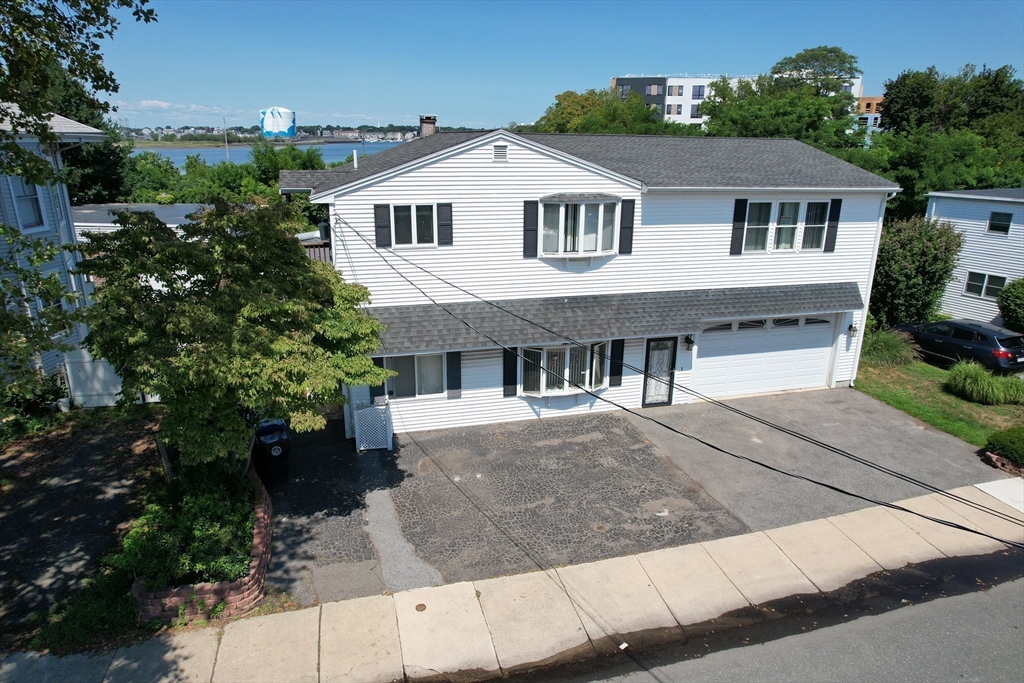 24 Webb Street Salem, MA 01970 - Photo 4 of 38 a front view of a house with a yard and garage