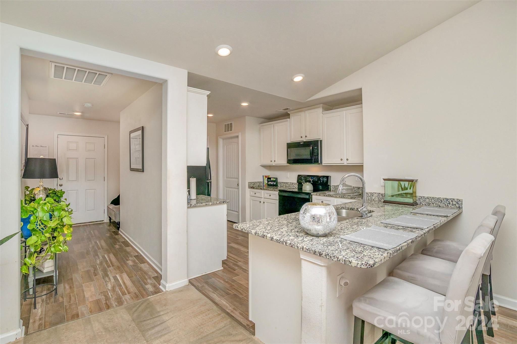 1075 Winding Creek Road Salisbury, NC 28146 - Photo 8 of 18 a kitchen with granite countertop kitchen island stainless steel appliances a refrigerator a stove a sink dishwasher and white cabinets with wooden floor