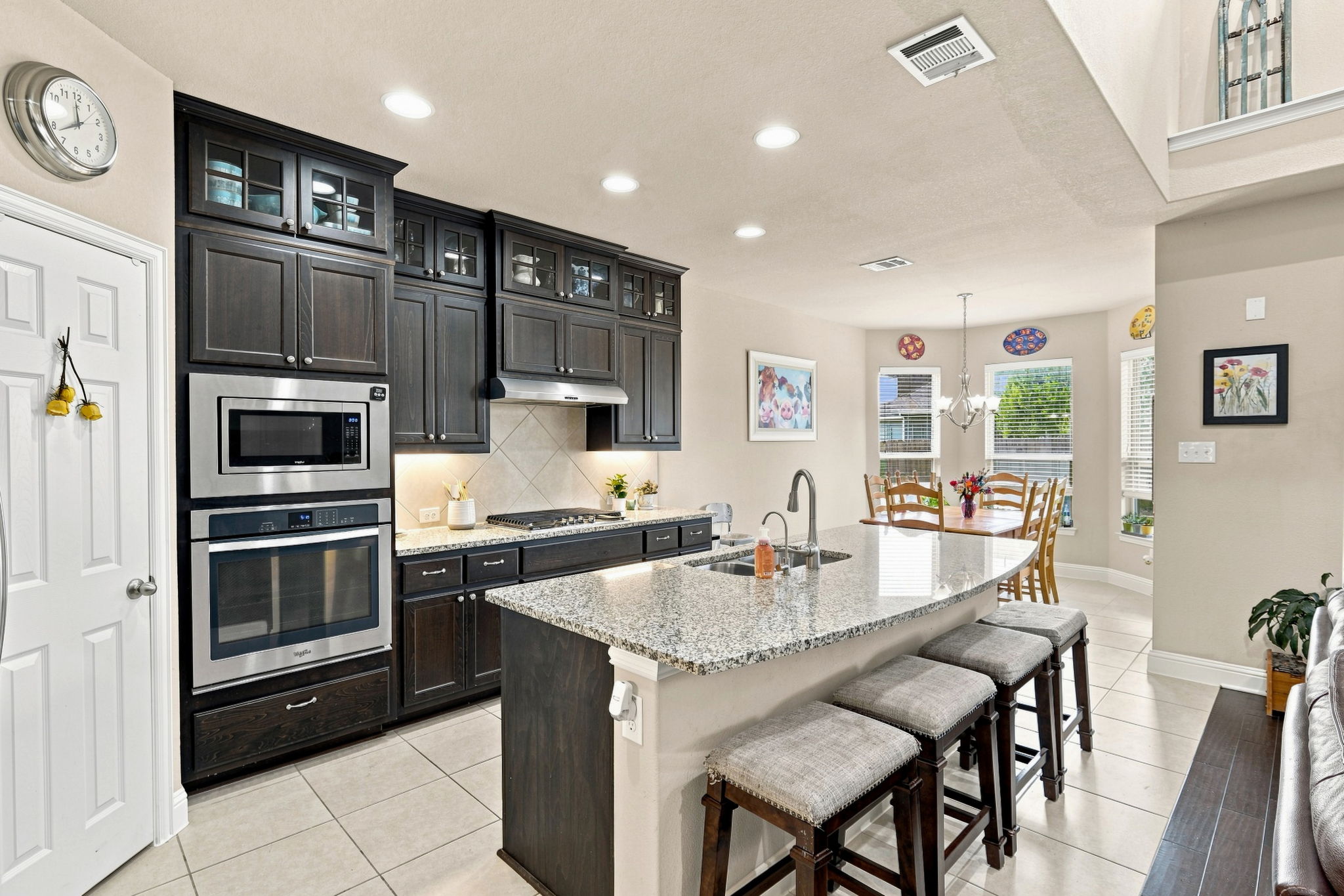 3237 Hidalgo Loop Round Rock, TX 78665 - Photo 5 of 31 Granite counters and dark cabinetry anchor this open culinary space under recessed lighting.