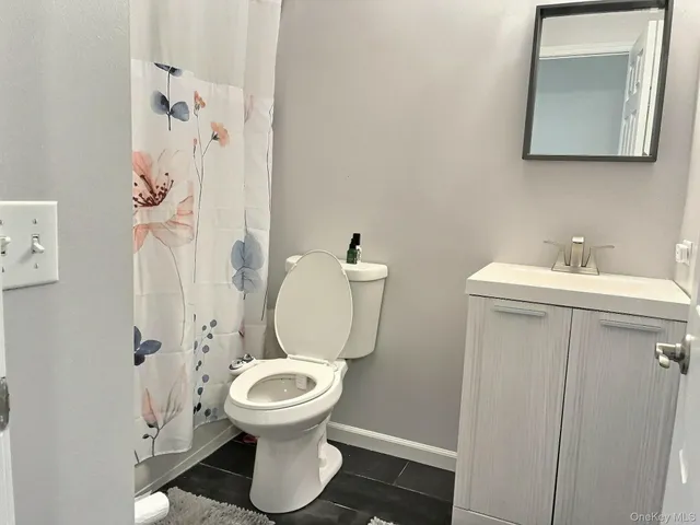a bathroom with a toilet sink and mirror