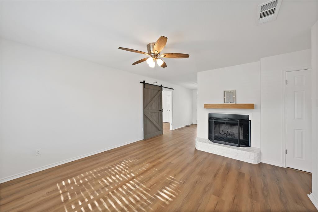 715 East Avenue F Midlothian, TX 76065 - Photo 3 of 33 a view of empty room with wooden floor and a fireplace