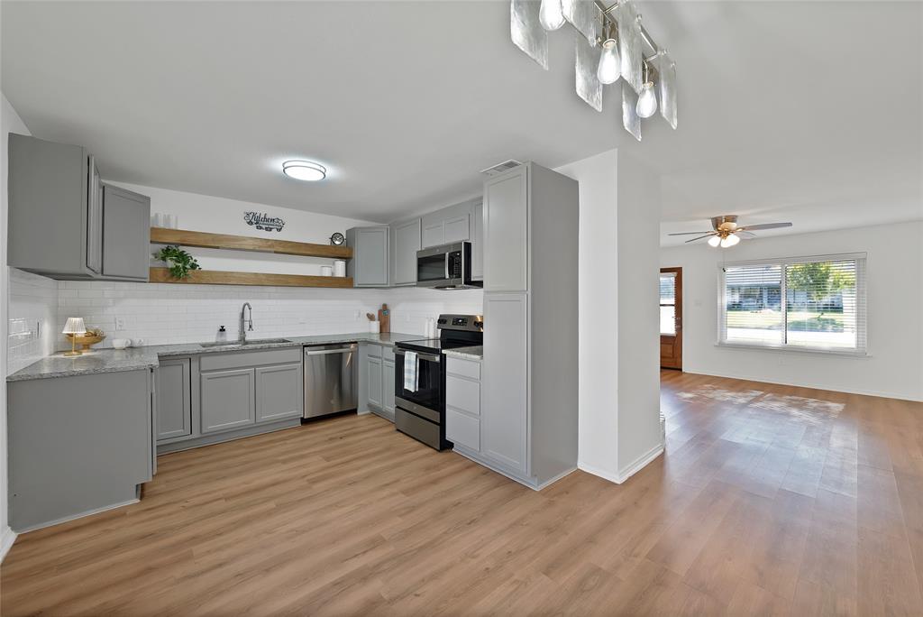 715 East Avenue F Midlothian, TX 76065 - Photo 6 of 33 a kitchen with stainless steel appliances granite countertop a sink cabinets and wooden floor