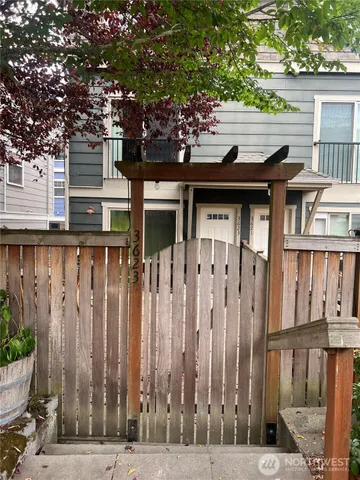 a side view of a house with a wooden fence