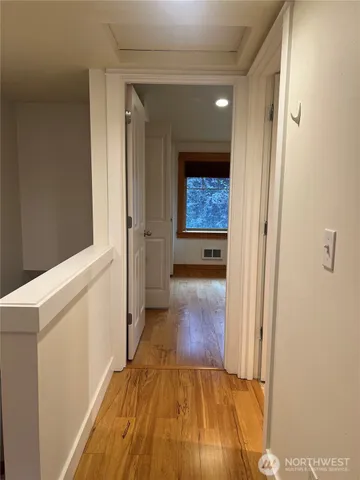 a view of a hallway with wooden floor and staircase