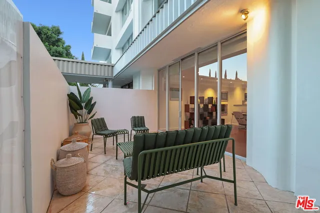 a bed sitting in a spacious bedroom next to a large window