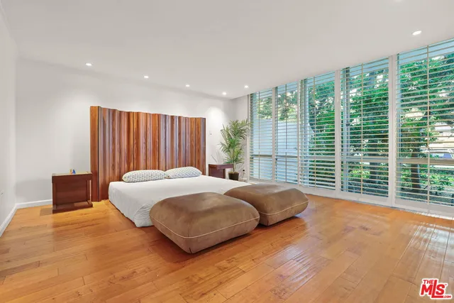 a spacious bedroom with a bed and a potted plant