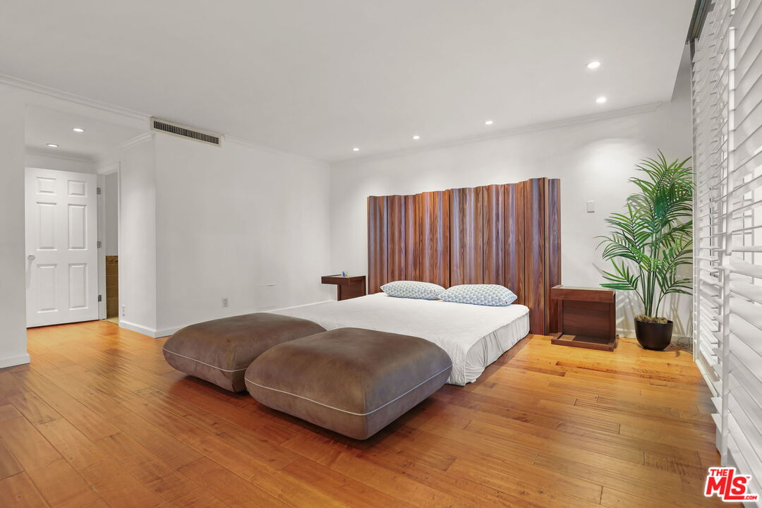 2170 Century Park East, Unit 104 Los Angeles, CA 90067 - Photo 15 of 42 a spacious bedroom with a bed and a potted plant