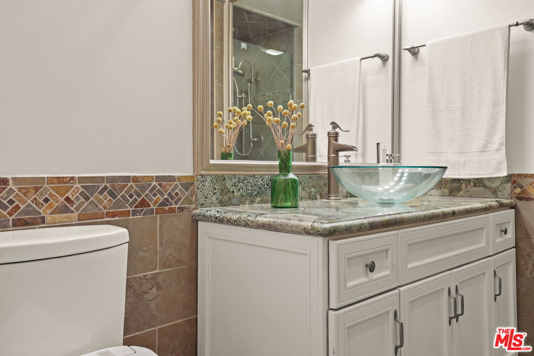 2170 Century Park East, Unit 104 Los Angeles, CA 90067 - Photo 19 of 42 a bathroom with a granite countertop sink and a mirror
